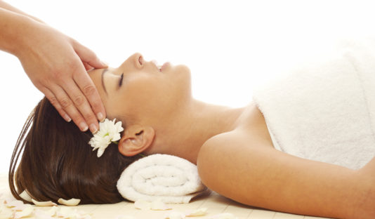 Young attractive girl receiving head massage at spa resort